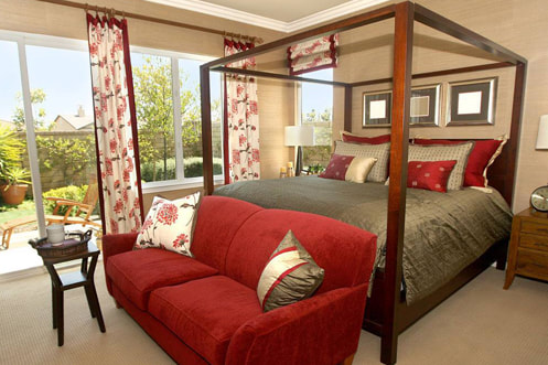Photo of a master bedroom with red accents and glass doors